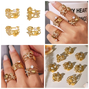 Detailed views of gold sea life rings featuring starfish, shell, and zircon accents