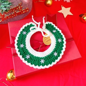 Detailed macro of green and white knit Christmas pet scarf with snowflake accents