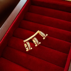 Detailed close-up of 18k gold plated zircon cartilage earring clip on red velvet