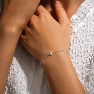 Close-up of S925 silver star bracelet with sparkling diamonds on a woman wrist