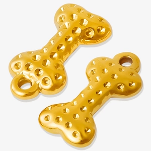 Macro detail of golden bone-shaped pendants with textured surface and hanging loops