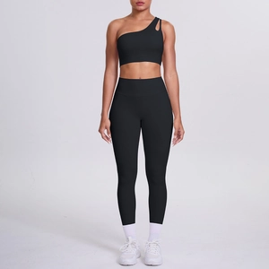 Detail of black one-shoulder sports bra and high-waisted leggings set on model