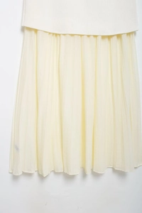 Detailed close-up showing the pleated chiffon texture and beige fabric of the midi skirt