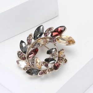 Elegant silver alloy olive branch wreath brooch with colorful crystals on white base