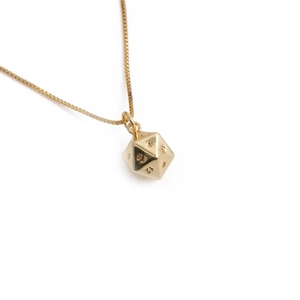 Macro shot of gold-plated D20 dice pendant featuring detailed numerical engravings