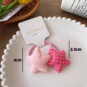 Detail of star-shaped plaid and polka dot fabric hair scrunchies on a ceramic tray
