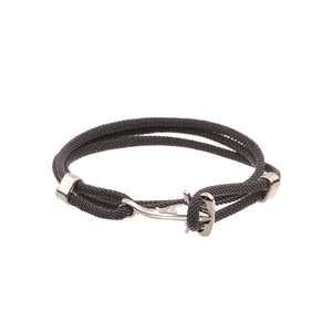 Macro detail of black braided nautical bracelet with silver anchor clasp on white background