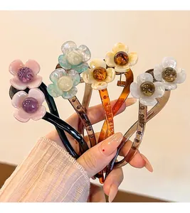 Détail de quatre barrettes banane à fleurs colorées avec perles élégantes au centre