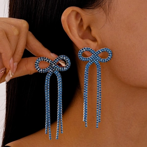 Détail de boucles d'oreilles nœud en strass bleu avec de longues franges