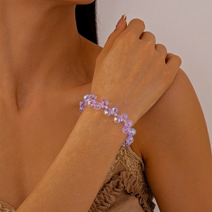Nahaufnahme eines lila facettierten Kristallperlenarmbands am Handgelenk mit glänzendem Glanz