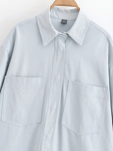 Close-up of light blue twill shirt jacket showing hidden placket and chest pockets