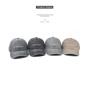 Four colors of washed vintage baseball caps with DADDY embroidery on white background