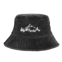 Close-up of white mountain and forest embroidery on black washed cotton bucket hat