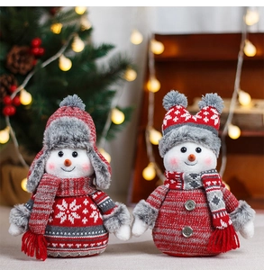 Detail of plush Christmas snowmen figurines wearing knit hats and snowflake sweaters