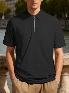 Close-up of black men's polo shirt featuring a silver metal zipper and textured knit fabric