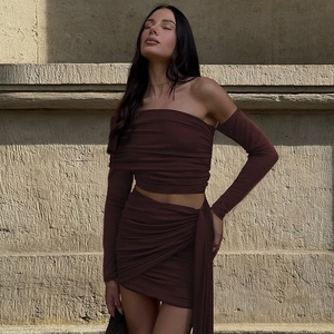 Detail of dark brown knit set with side ruching on the mini skirt and off-shoulder top