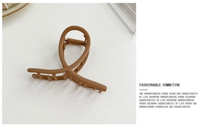Detail of matte coffee brown hair claw clip with anti-slip teeth and modern spiral design