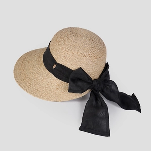 Détail du tissage en raphia naturel et élégant nœud en ruban gros-grain noir sur le chapeau