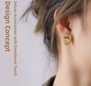 Gros plan d'un mannequin portant des boucles d'oreilles torsadées dorées au style moderne