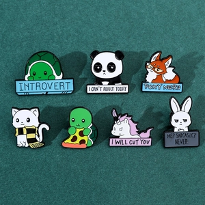 Detailed flat lay of colorful enamel animal pins on a professional dark green felt surface