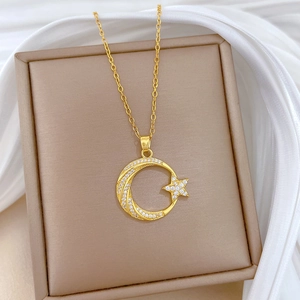 Gros plan du collier en acier titane doré avec pendentifs lune et étoile brillants
