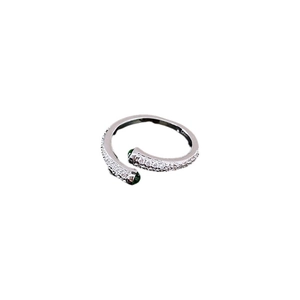 Bague ouverte argentée minimaliste avec pavé de zircons et deux pierres vertes sur fond blanc