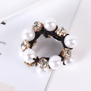 Detailed view of handmade hair tie featuring white pearls and sparkling rhinestones