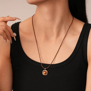 Detail showing resin pendant on adjustable brown woven cord for minimalist style