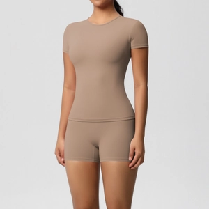 Detail of slim-fit brown yoga set featuring high-waisted shorts and short-sleeve top