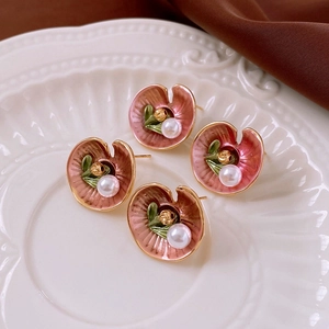 Vintage floral pearl stud earrings with pink enamel lotus leaf design on white ceramic tray