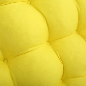 Detail shot of bright yellow quilted chair cushion showing textured fabric and stitching