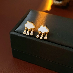 Detailed macro view of cloud-shaped gold earrings with zircon waterdrop charms