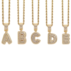 Detailed macro of gold iced-out hip hop necklaces with A to E letters and CZ stones