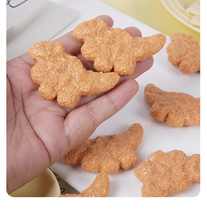 Texture détaillée de breloques nuggets de poulet en forme de dinosaure en résine jaune