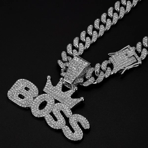 Detailed close-up of a silver Cuban chain necklace with a rhinestone BOSS crown pendant