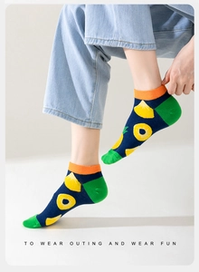 Detail of blue cotton low cut ankle sock with pineapple pattern and green cuff