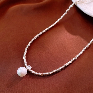 Détail macro du collier pendentif perle avec zircon et perles facettées argentées