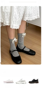 Detail of grey ballet style socks with white lace bows and wavy trim paired with shoes