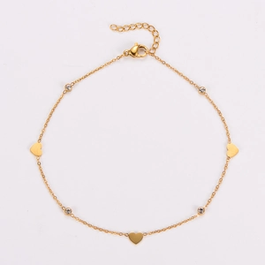 Close-up of golden heart anklet with sparkling zircon charms and adjustable clasp
