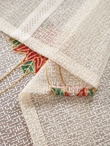 Detailed macro view of American Christmas tablecloth with green and red bell embroidery