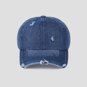 Close-up of distressed navy denim baseball cap with vintage frayed edges and ripped details