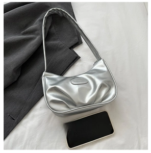 Détail d'un sac hobo argenté métallisé avec texture plissée et logo de marque en métal