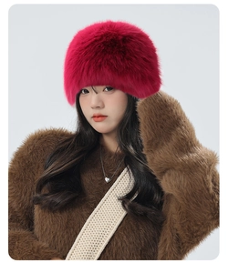 Close-up of fluffy rose red faux fur winter hat with thick plush texture for cold weather