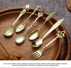 Detailed view of vintage gold dessert spoons with ornate carvings on a wooden tray