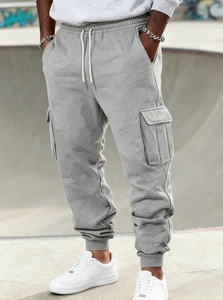 Detail of grey joggers with functional cargo pockets and drawstring waist for men