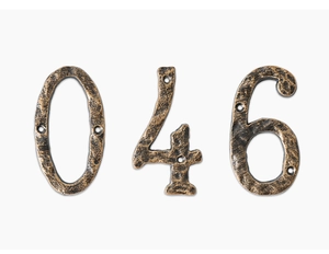 Macro detail of vintage cast iron house numbers 0, 4, and 6 with antique bronze finish
