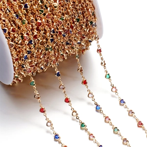 Macro shot of gold metal chain featuring multicolored heart-shaped zircon stones