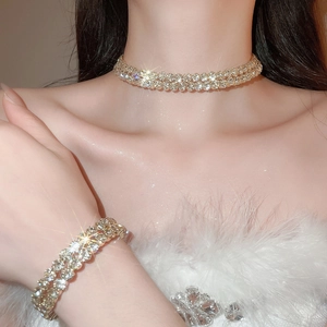 Detailed view of luxury gold jewelry set with shimmering crystals worn by a model