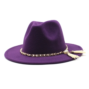 Detail of purple wool fedora hat featuring gold chain, white pearls and side tassels