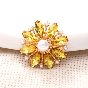 Macro view of sunflower charm with gold base, yellow marquise gems and white pearls